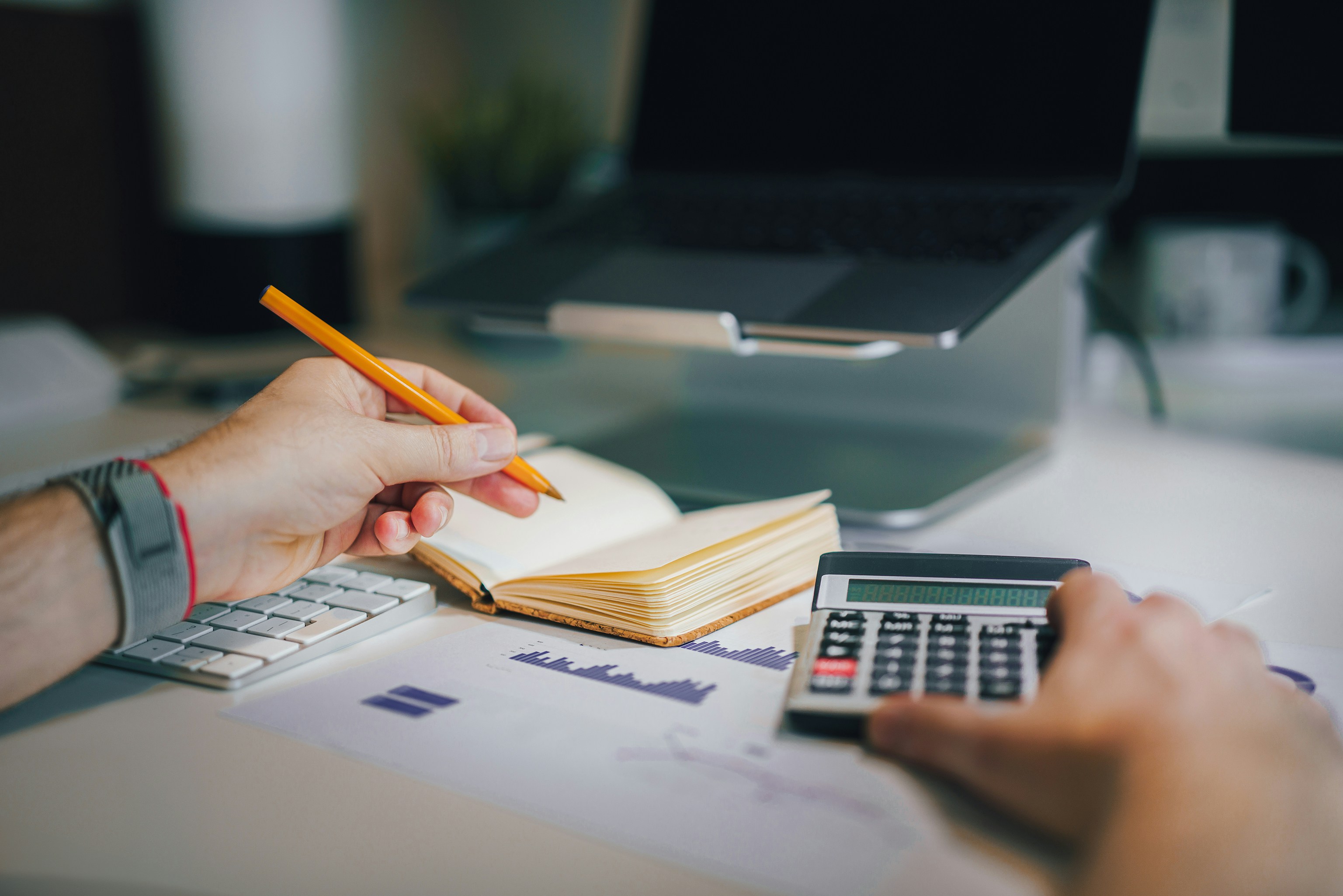 Person reviewing mortgage affordability numbers with calculator and notebook